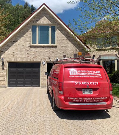 SOS Garage Door Repairs' service van in front of a house